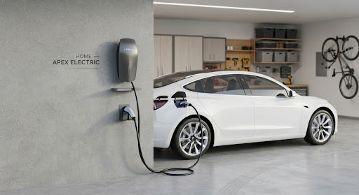 Modern EV charging station on a garage wall with a white vehicle parked nearby